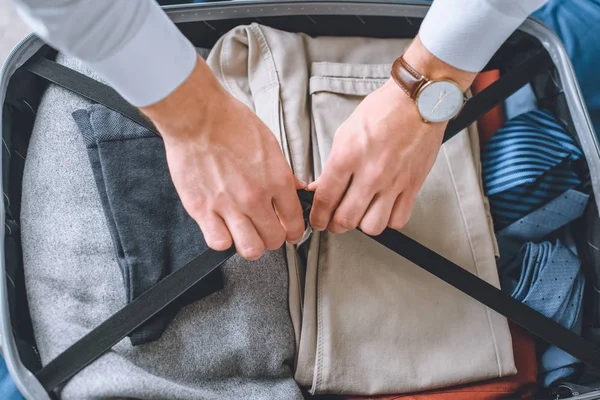 スーツケースに荷物をパッキングの腕時計でビジネスマンをイメージをトリミング — ストック写真