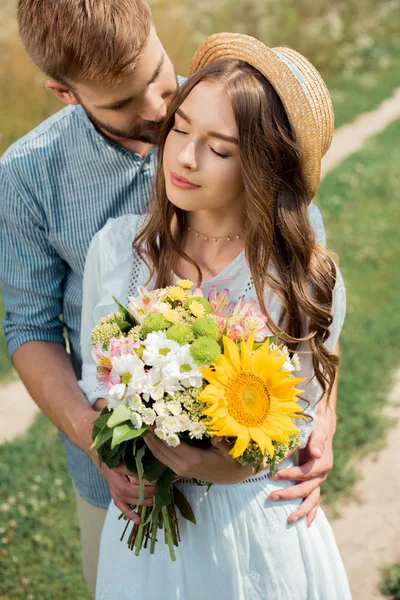 Zarter Mann Umarmt Freundin Mit Strauß Wildblumen Sommerfeld — Stockfoto