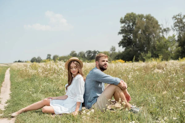 Pareja Joven Descansando Espalda Con Espalda Manta Campo Con Flores — Foto de Stock