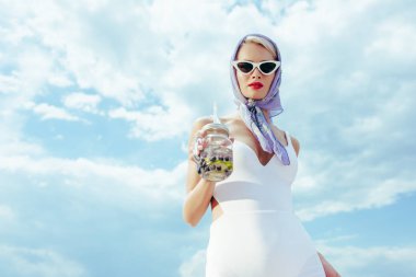 güneş gözlüğü ve mason kavanoza taze içki ile tutarak vintage mayo moda kız
