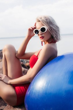 kız kırmızı bikini ve güneş gözlüğü mavi fitness Ball kayalık plaj rahatlatıcı