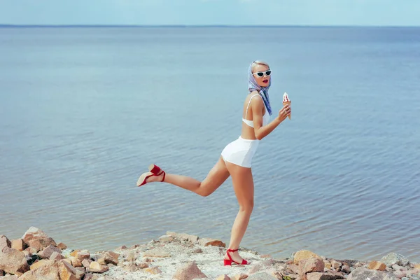 Jovem Mulher Maiô Retro Segurando Sorvete Posando Praia Rochosa — Fotografia de Stock