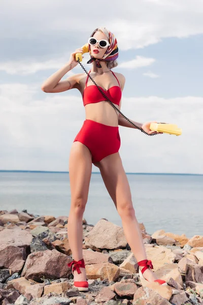 Stylowy Kobieta Czerwonym Bikini Jedwabny Szal Rozmawia Żółty Telefon Obrotowe — Darmowe zdjęcie stockowe