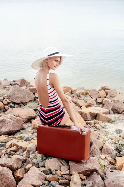 Attraktives Mädchen Vintage Badeanzug Sitzt Auf Reisetasche Felsigen Strand — kostenloses Stockfoto