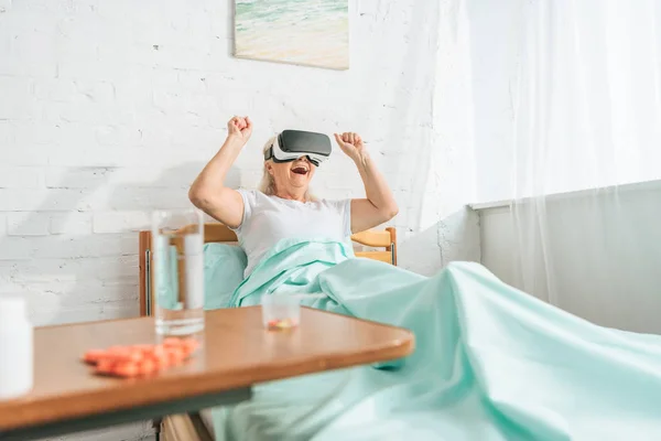 Mulher Sênior Animado Usando Fone Ouvido Realidade Virtual Enquanto Deitado — Fotografia de Stock