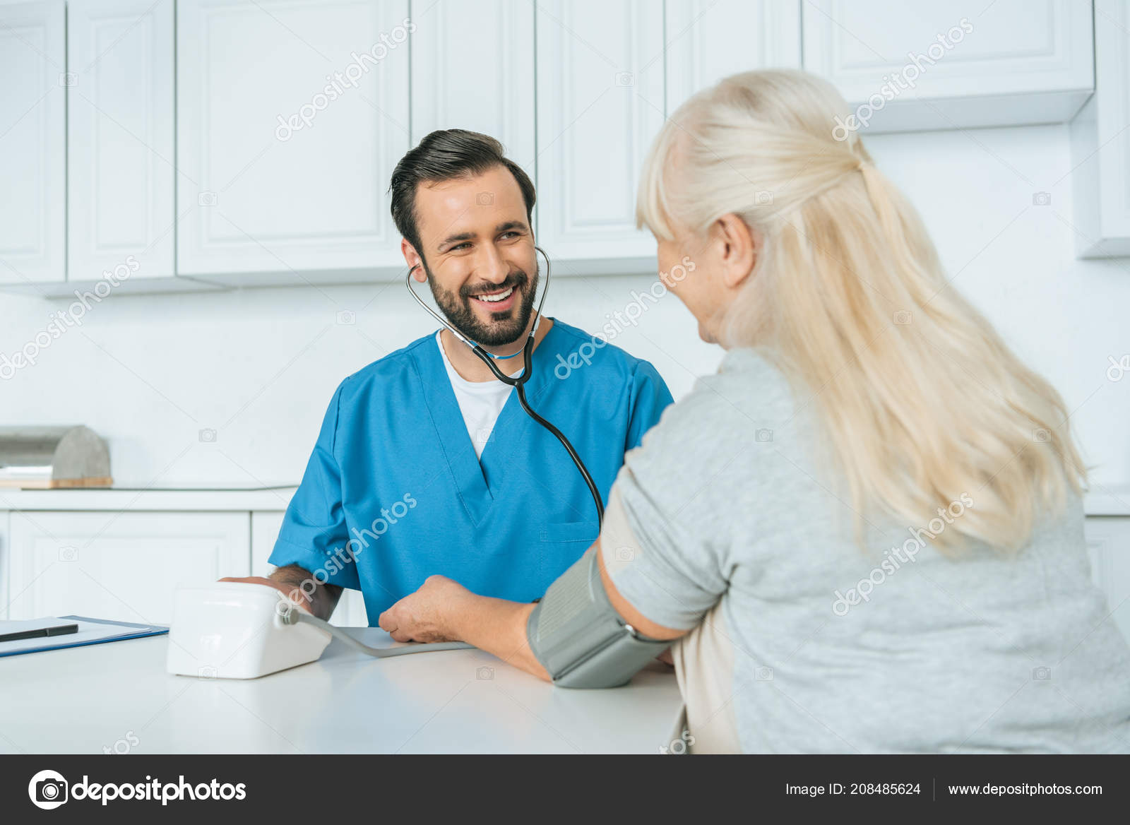 Smiling Male Nurse Measuring Blood Pressure Senior Woman Stock