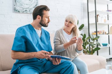 hapları tutan üst düzey kadın seyir Pano ile erkek bakıcı 