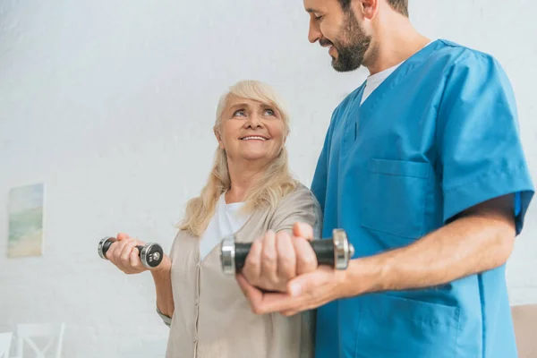 Cropped Shot Social Worker Helping Smiling Senior Woman Exercising Dumbbells — Stock Photo, Image