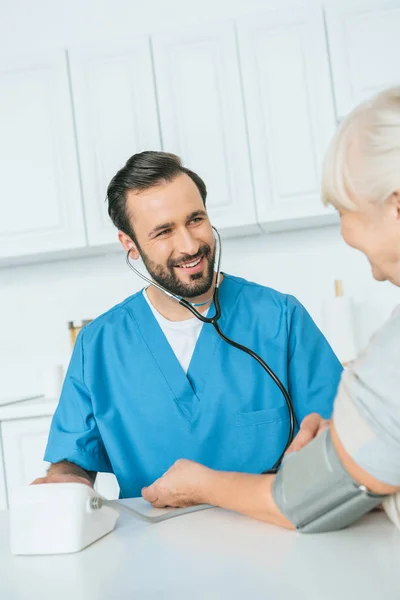 Tiro Recortado Enfermeira Sorridente Sexo Masculino Medir Pressão Arterial Para — Fotografia de Stock