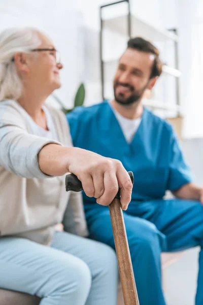 Vista Cerca Mujer Mayor Sosteniendo Bastón Mirando Sonriente Trabajador Social — Foto de Stock