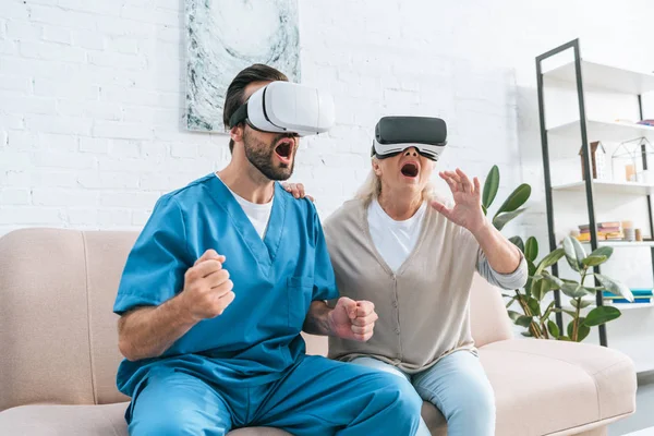 emotional social worker and excited senior woman using virtual reality headsets