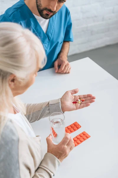 Bijgesneden Schot Van Verzorger Kijken Naar Zieke Senior Vrouw Innemen — Stockfoto