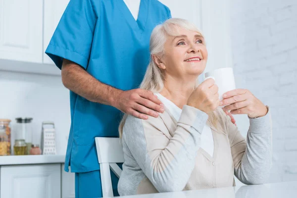 Cropped Shot Caregiver Standing Happy Senior Woman Drinking Tea Kitchen — Free Stock Photo