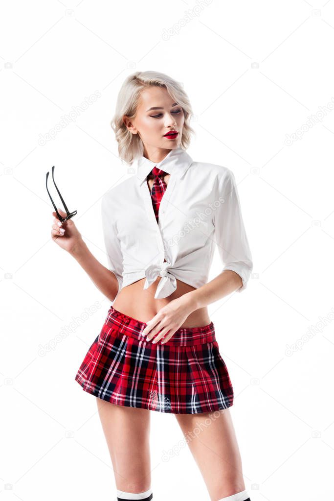 portrait of sexy young woman in short schoolgirl plaid skirt with eyeglasses posing isolated on white