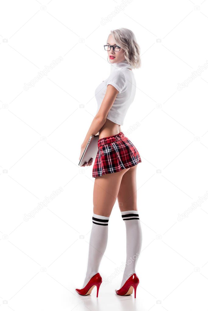 young woman in seductive schoolgirl uniform with laptop isolated on white