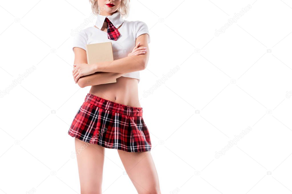 partial view of sexy woman in schoolgirl clothing holding book isolated on white
