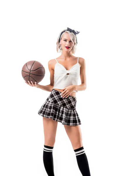 在短的女学生裙子的诱人的妇女与篮球球隔绝在白色 — 图库照片