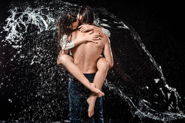 セクシーな若いカップルの背面はブラックに分離された水で Swilled ストック写真