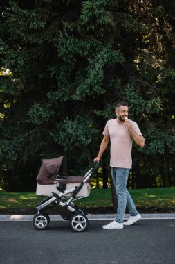 gülümseyen baba bebek arabası ve dondurma Parkı ve geri arıyor ile yürüme