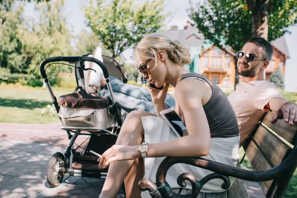 Mor Rökning Cigarett Nära Barnvagn Park Och Prata Genom Smartphone — Stockfoto