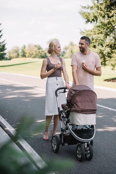 Orang Tua Tersenyum Berjalan Dengan Kereta Bayi Dan Krim Taman — Stok Foto