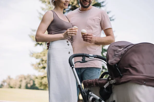Cropped Image Parents Holding Ice Cream Looking Baby Carriage Park — Stock Photo, Image