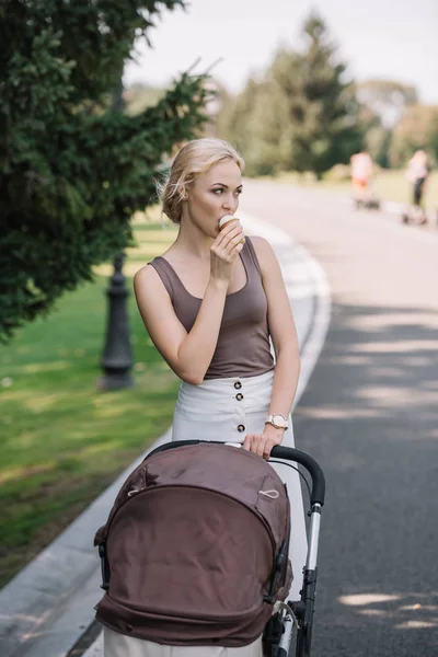 Portrait Mother Walking Baby Carriage Eating Ice Cream Park — Free Stock Photo
