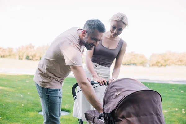 Smiling Parents Looking Baby Carriage Park — Stock Photo, Image