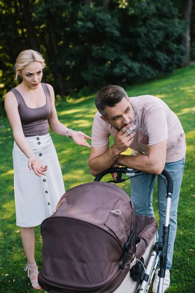 Father Smoking Cigarette Baby Carriage Park Angry Mother Gesturing Looking — Stock Photo, Image