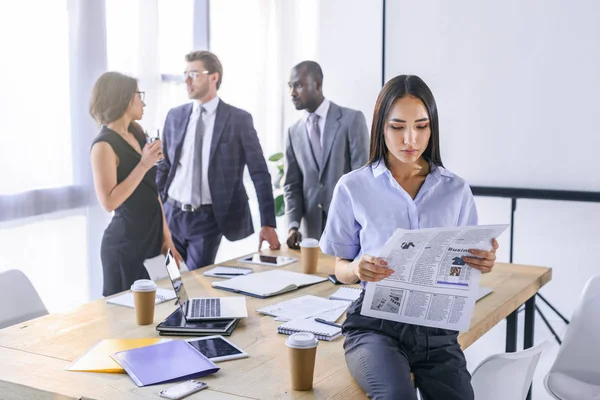 Selective Focus Asian Businesswoman Reading Newspaper Colleagues Having Conversation Office — Stock Photo, Image