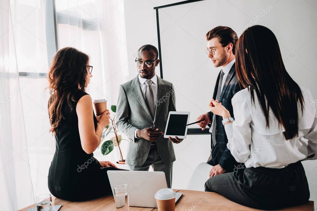 group of multiracial business coworkers in formal wear discussing new business plan in office