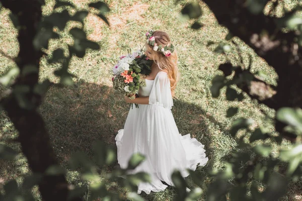 公園内の花の花束を持って美しい柔らかい若い花嫁のハイアングル — ストック写真