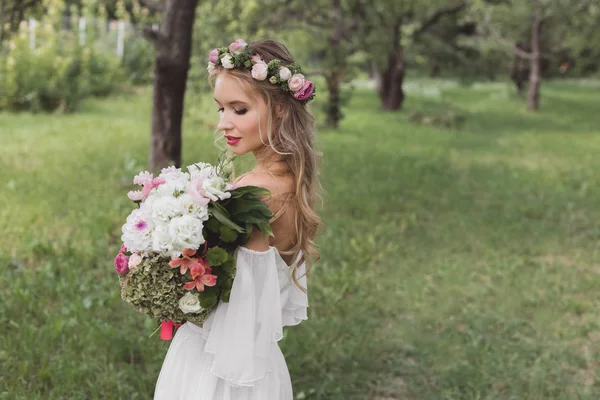 公園内の花の花束を持って花の花輪の柔らかい若い花嫁のハイアングル — ストック写真