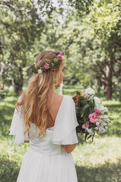 Widok Tyłu Pięknej Narzeczonej Wieniec Kwiatowy Trzymając Bukiet Ślubny — Zdjęcie stockowe