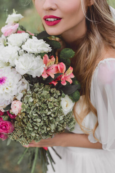крупным планом вид нежной блондинки невесты с красивым букетом цветов
