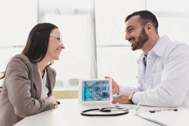 gülümseyen doktor klinikte hasta tablet tıbbi app ile gösterilen