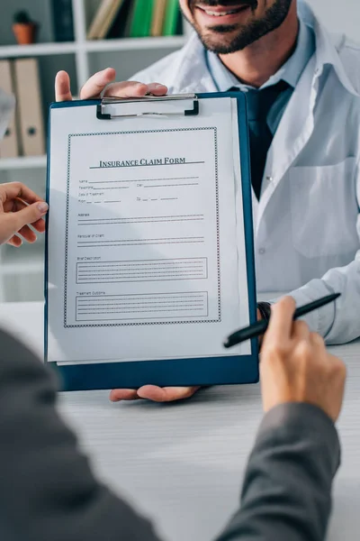 Imagem Cortada Médico Mostrando Formulário Pedido Seguro Para Paciente Clínica — Fotografia de Stock Grátis