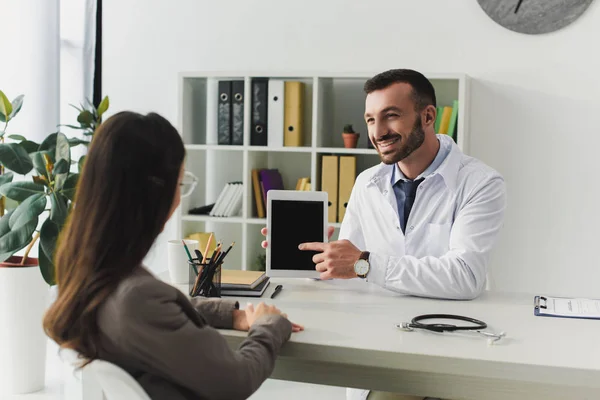 Médico Sonriente Apuntando Tableta Con Pantalla Blanco Paciente Clínica —  Fotos de Stock