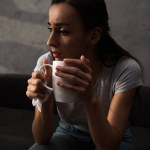 Osamělá smutná žena držící šálek kávy
