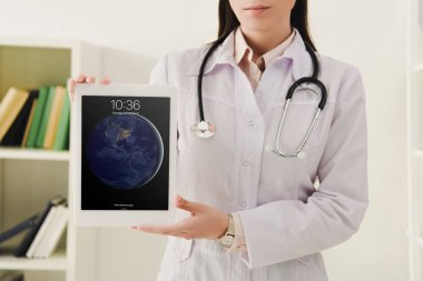 Doktor görünümünü stetoskop ile ipad gösterilen kırpılmış 