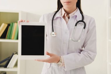 Doktor görünümünü dijital tablet boş ekran ile gösterilen stetoskop ile kırpılmış
