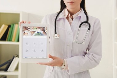 Doktor oturaklı cihaz dijital tablet sunan görünümünü kırpılmış