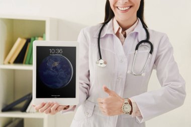 bir başparmak gösterilmesini ve ipad sunma Doktor kırpılmış görünümü