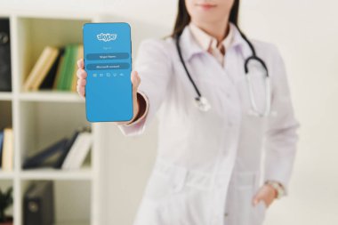 Doktor smartphone skype cihaz ile sunan görünümünü kırpılmış