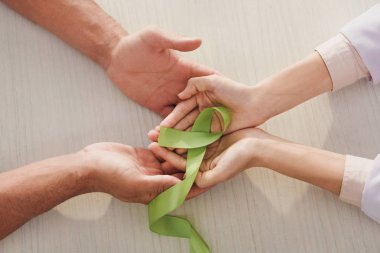 yeşil şerit - erkek ve kadın elleriyle kısmi görünümünü ruh sağlığı günü