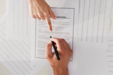 Doktor ona işaret ederken sigorta hasar talep formu imzalama istemci kırpılmış görünümünü