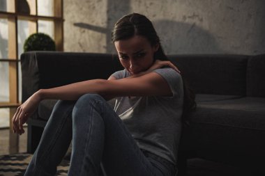 Ağlama ve katta oturan depresif kadın