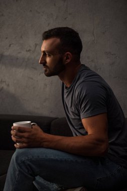 evde kahve fincanı tutan üzgün yalnız adam