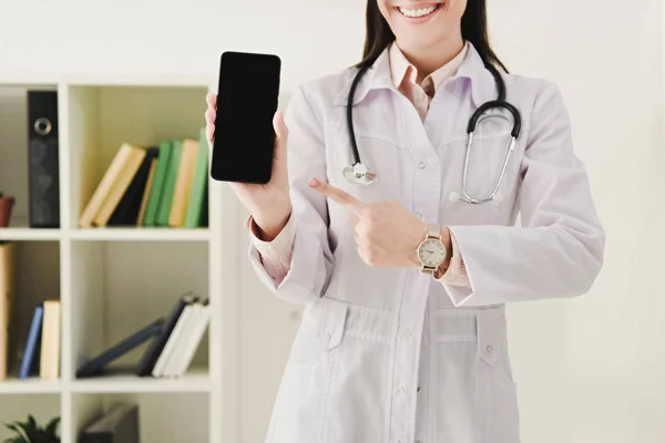 Vista Ritagliata Del Medico Che Punta Smartphone Con Schermo Vuoto — Foto stock gratuita