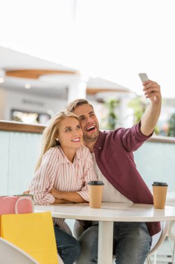 smartphone kafede selfie alarak kahve fincanı ile masadaki genç çift 